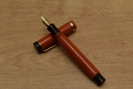 A Parker Junior Duofold Lucky Curve button fill fountain pen in Red with single cap band having