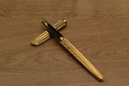 A Waterman converter fill fountain pen in Gold plated Moire pattern having 18k 750 nib. Circa 1971