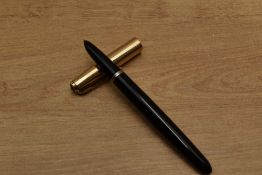 A Parker 51 aerometric fill fountain pen in Black with gold filled converging line cap. Circa 1950
