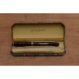 A boxed Conway Stewart 58 lever fill fountain pen in Tiger's Eye with one broad and two narrow cap