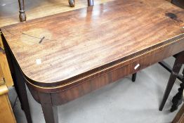 A 19th Century mahogany fold over tea table having satinwood edging amd square tapered legs, width