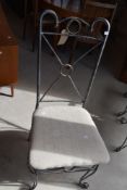 A set of four modern metal chairs having upholstered seats