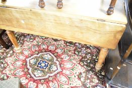 A 19th century drop leaf Pembroke style table having short drop flaps and turned legs, approx. Width