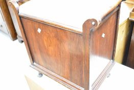 An early 20th Century mahogany music stool, having drop flap to front (af), width approx. 53cm
