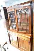 A Victorian mahogany bookcase having gothic glazed upper section with drawer and double cupboard