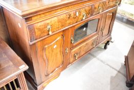 A late 19th or early 20th Century mahogany and walnut sideboard having two frieze drawers with