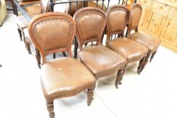 A set of twelve (ten plus two) Victorian oak dining chairs having spoon backs and overstuffed seats,