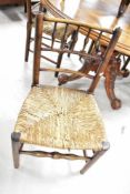 A set of four 19th Century kitchen chairs having spindle backs and rush seats