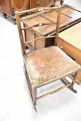 A 19th Century rail back rocking chair having rush seat with later dralon upholstery over