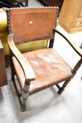 An early 20th Century oak carver chair having studded leather seat