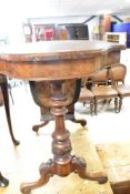 A Victorian walnut sewing table having turned foliate frame with shaped top, in need of some
