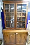 A rustic Victorian stained frame bookcase with double cupboard, dimensions approx. Width 127cm,