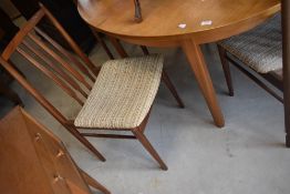 A vintage teak dining table and set of four rail back dining chairs, possibly McIntosh snd /or G