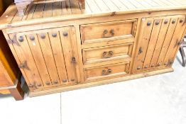 A mexican pine rustic style sideboard having three central drawers flanked by cupboards,