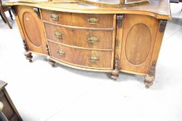 A Victorian walnut sideboard having serpentine top over three central bow fronted drawers with