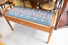 An early 20th Century mahogany duet piano stool, having tapestry lift seat with double compartment
