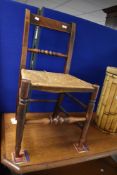 A 19th Century rush seated dining chair having turned rail and front stretcher