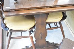 A dark stained Ercol drawer leaf dining table and set of four similar Ercol chairs