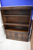 A dark stained Ercol or similar bookshelf with double cupboard under, dimensions approx. height