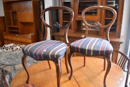 A pair of Victorian mahogany salon chairs having later stripe upholstery