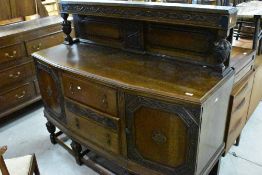 An early 20th Century oak ledge back sideboard having carved decoration, width approx. 150cm