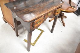 A 19th Century oak lowboy in the Georgian style with brass drawer handles and shaped apron, on