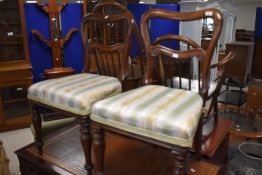 A pair of Victorian mahogany railback dining chairs having overstuffed seats with later upholstery