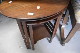 An early 20th Century mahogany nest of three table, the top one being oval, approx. 58 x 40cm