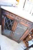A vintage dark stained Priory style corner display and set of four similar dining chairs with