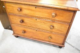 A Victorian mahogany chest of three long drawers having ledge back, turned handles and feet,