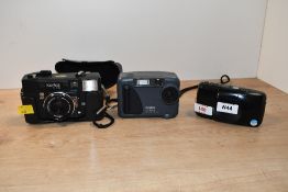 Three cameras. An Olympus U Zoom, a Konica C35 and a Kodak DC3200 digital camera