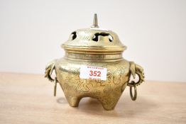 A late 19th-century Chinese brass incense burner, featuring a pierced lid with etched traditional