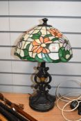 A late 20th-century Tiffany-style table lamp, featuring colourful orange and purple floral shade,