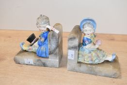 A pair of mid 20th-century German-style Onyx bookends with porcelain figural detailing, to feature a