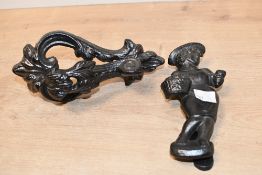 Two vintage cast iron door knockers, to feature a 'farmer boy' and an ornate foliate example,
