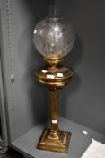A Victorian Corinthian column-style brass oil lamp, featuring an acid-etched floral globe-formed