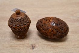 Two 19th-century carved Coquilla nut cases, featuring intricate pierced carvings, one holds a