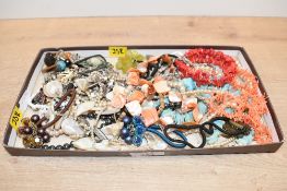 An assortment of costume jewellery, including shell and coral necklaces, beaded necklaces and faux