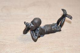 A fine Bergman bronze figure of a boy lying on his stomach smoking a pipe, stamped with mark to