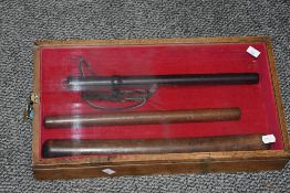 A group of three turned wooden fishing priests, housed in a wooden and perspex display case, largest