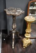 A late 19th to early 20th-century Indo Persian-style dark wood tripod table, featuring mother-of-