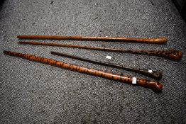 Four 20th-century natural wood walking sticks, of varying styles and lengths, three longest