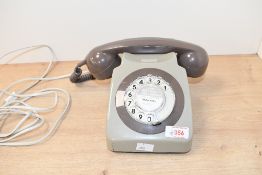 A vintage GPO 746-style rotary dial telephone, featuring a warm brown handset and a grey body,