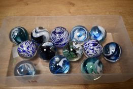 A collection of thirteen modern decorative glass over-sized marbles each with swirled designs,