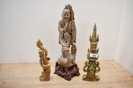 A substantial Chinese soapstone sculpture, depicting a traditional fisherman seated upon a rocky
