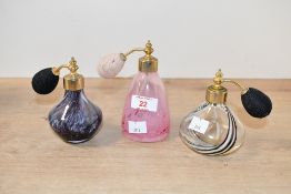 Three late 20th-century art glass atomisers, to feature a tall swirled pink example and two
