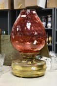 A large and decorative Victorian brass and cranberry glass footwamer heat lamp of oversized oil lamp