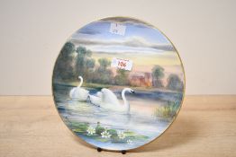 A 20th-century decorative Swan plate, featuring a pair of hand painted Swans against a pastoral lake