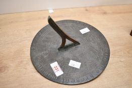 A cast brass antique style sundial with shaped gnomon and wording 'Seize the present moment the