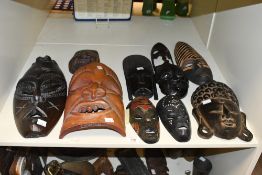 A collection of African tribal and Asian carved wooden decorative masks, various including Thai